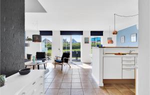 布罗Cozy Home In Brenderup Fyn With Wifi的厨房配有白色橱柜和桌椅