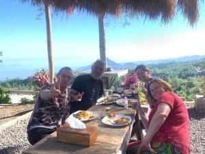 GitgitWanagiri Campsite的一群坐在餐桌上吃食物的人