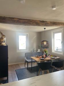 Rosehill Cottage 1699 - Stilvolle Ferien Berge & Seen的一间带桌椅和2扇窗户的用餐室