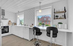 腓特烈港4 Bedroom Lovely Home In Frederikshavn的白色的厨房,配有两把黑椅子