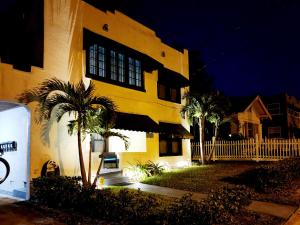莱克兰TWO BEDROOM HOME IN BEAUTIFUL DOWNTOWN LAKELAND的一座棕榈树的黄色建筑