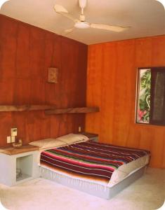 埃斯孔迪多港Casa KUUL, elegant fusion of house and garden.的一间卧室设有一张木墙床和天花板