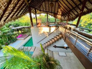 埃斯孔迪多港Casa KUUL, elegant fusion of house and garden.的一个带游泳池和草屋顶的度假胜地