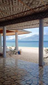 比拉Home Stay Ramli的享有海滩美景,设有凉亭和大海
