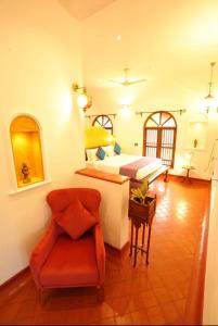 马拉利库兰Marari Beach Bungalow的一间卧室,卧室内配有一张床和一把椅子