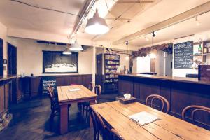 札幌瓦亚旅馆的一间带两张木桌的餐厅和一间酒吧