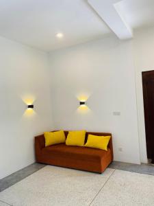 乌纳瓦图纳Oshi villa的一张沙发,里面配有两个黄色枕头
