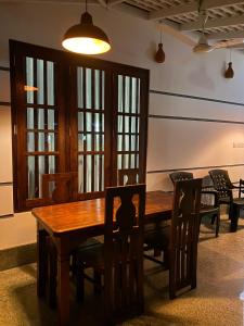 乌纳瓦图纳Oshi villa的一间带木桌和椅子的用餐室