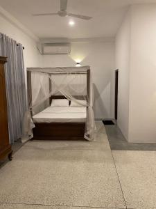 乌纳瓦图纳Oshi villa的一间卧室配有一张带蚊帐的床