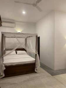 乌纳瓦图纳Oshi villa的一间卧室配有一张带天蓬的床