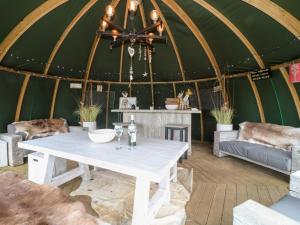 诺丁汉Herbie's Shepherds Hut的蒙古包内的一张桌子,配有沙发和椅子