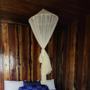 瓜隆岛Blondies Koh Rong Villa的天花板上挂着窗帘的床