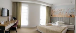 德瓦Vila Sarisa的卧室配有一张床、一张书桌和窗户。
