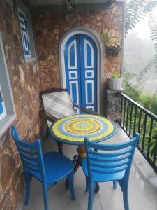 埃拉The black stone的阳台配有一张桌子和椅子,阳台设有蓝色的门