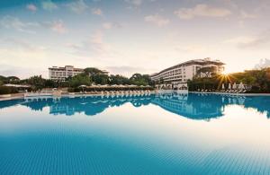 贝莱克Ela Excellence Resort Belek的一座大型游泳池,其建筑背景为: