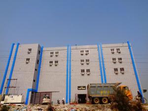 王舍城Hotel Glory Grand, Rajgir的前面有一辆倾卸卡车的大建筑