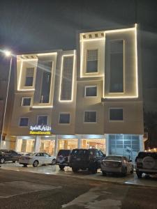 麦地那فندق زوايا الماسية فرع الحزام的停车场内停放汽车的大型建筑
