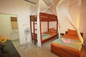 纳闽巴霍曼塔曼塔旅馆的一间卧室设有两张双层床和风扇