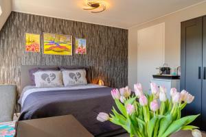希勒霍姆Liv Inn的一间卧室配有一张床和一张带粉红色郁金香的桌子。