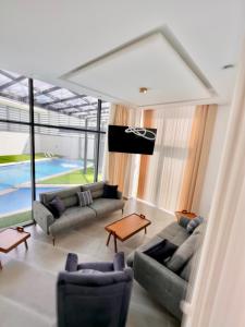 杰里科Granada Villas的带沙发和电视的客厅以及游泳池。