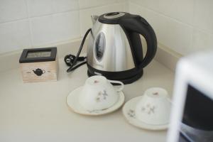 滨海波利尼亚诺Io, te e il mare的黑白茶壶和柜台上的两个杯子