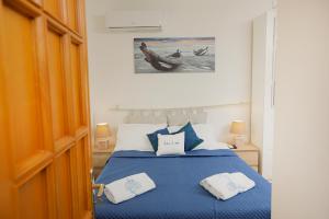 滨海波利尼亚诺Io, te e il mare的一间卧室配有蓝色的床和2条毛巾