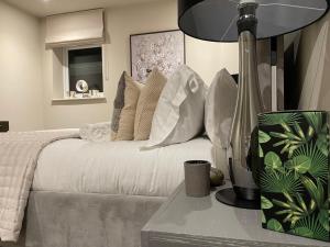 齐格威尔Stunning 2BA, 2BR Apt, Desirable Chigwell CHCL F6的一间卧室配有带白色枕头和灯的床