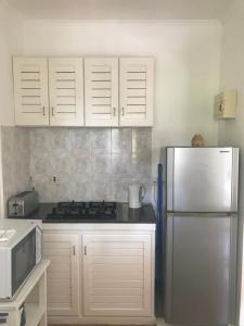 昂斯布瓦洛太阳鸟简易别墅酒店的厨房配有白色橱柜和冰箱。