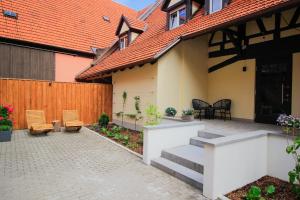 布格贝恩海姆Gasthof Pension Zum goldenen Hirschen的一个带椅子的庭院和一个带围栏的房子