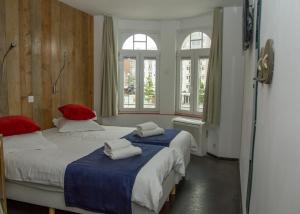 德帕内安扎酒店的带2扇窗户的客房内的2张床