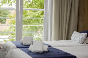 德帕内安扎酒店的一间卧室设有两张床和大窗户