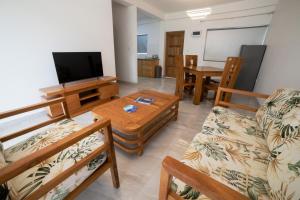 安塞罗亚莱kannel Apartments的客厅配有沙发和桌子