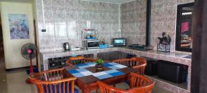 高兰Tonmai Aquablue的厨房配有桌子、椅子和柜台