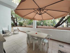 卡斯特拉巴特滨海Collins Apartments的庭院里配有桌椅和遮阳伞