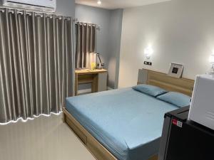 Ban Pa ToemThe Northern MFU的一间卧室配有一张带蓝色床单的床和一扇窗户。