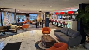 博韦Hostellerie Saint Vincent Beauvais Aeroport的一个带沙发和椅子的大堂和一间酒吧