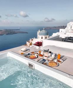 易莫洛林Cilon Suites Santorini的游泳池畔的食品托盘