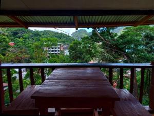 爱妮岛BaleCabugaoCottagesRental的阳台上的木桌享有树木的景致。