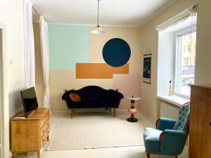 赫尔辛基Spacious (44 sqm) bohemian studio in trendy Kallio的带沙发和电视的客厅