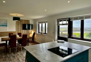 纽基Valley Lodge House - Porth Newquay的一间带桌子的客厅和一间餐厅