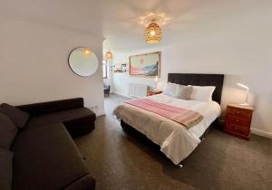 纽基Valley Lodge House - Porth Newquay的一间卧室配有一张床和一张沙发
