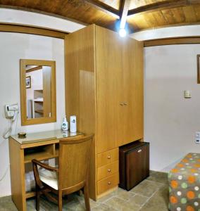 米蒂利尼TARLAS ROOMS的客房设有书桌、床和镜子
