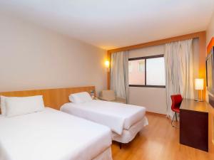 大坎普大坎普诺富特坎酒店的酒店客房设有两张床和窗户。