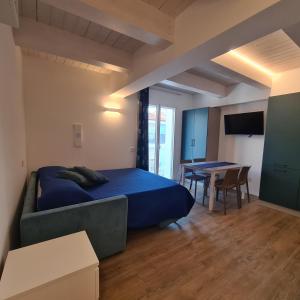 雷卡纳蒂港Appartamenti nuovi in centro a Porto Recanati Riviera del Conero的一间卧室配有一张蓝色的床和一张桌子