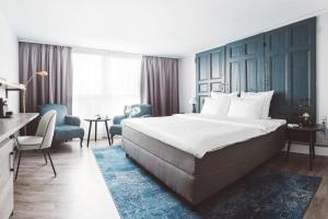 柏林Hotel Berlin, Berlin, a member of Radisson Individuals的酒店客房设有一张大床和一张书桌。
