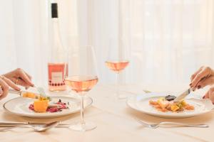 阿姆施泰滕埃克塞尔酒店的一张桌子,上面放着两盘食物和酒杯