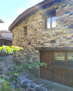 O Busto Aldea Rural的石头房子,设有木制车库门