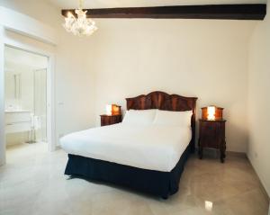 穆拉诺Ca' Mazzega的卧室配有一张白色大床和吊灯。
