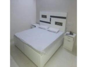 索尼帕特City Plaza, Sonipat的白色客房内的一张白色床,