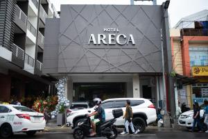 黎牙实比Hotel Areca的在酒店区域前骑摩托车的人